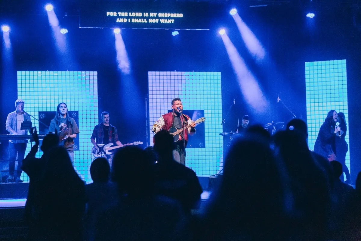Joshua Ali leading worship with a full band