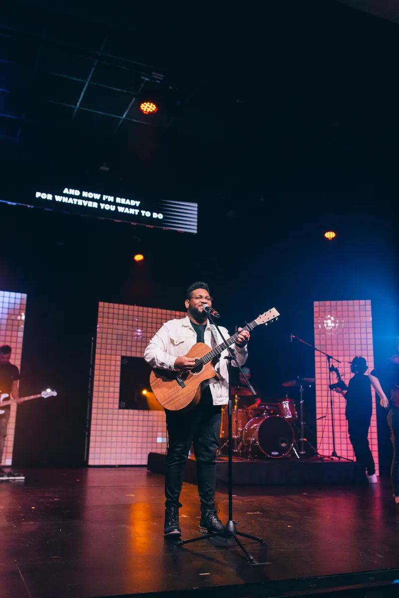 Joshua Ali performing on stage with guitar