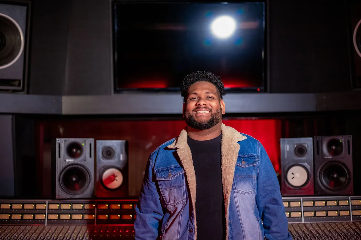 Joshua Ali smiling in his studio
